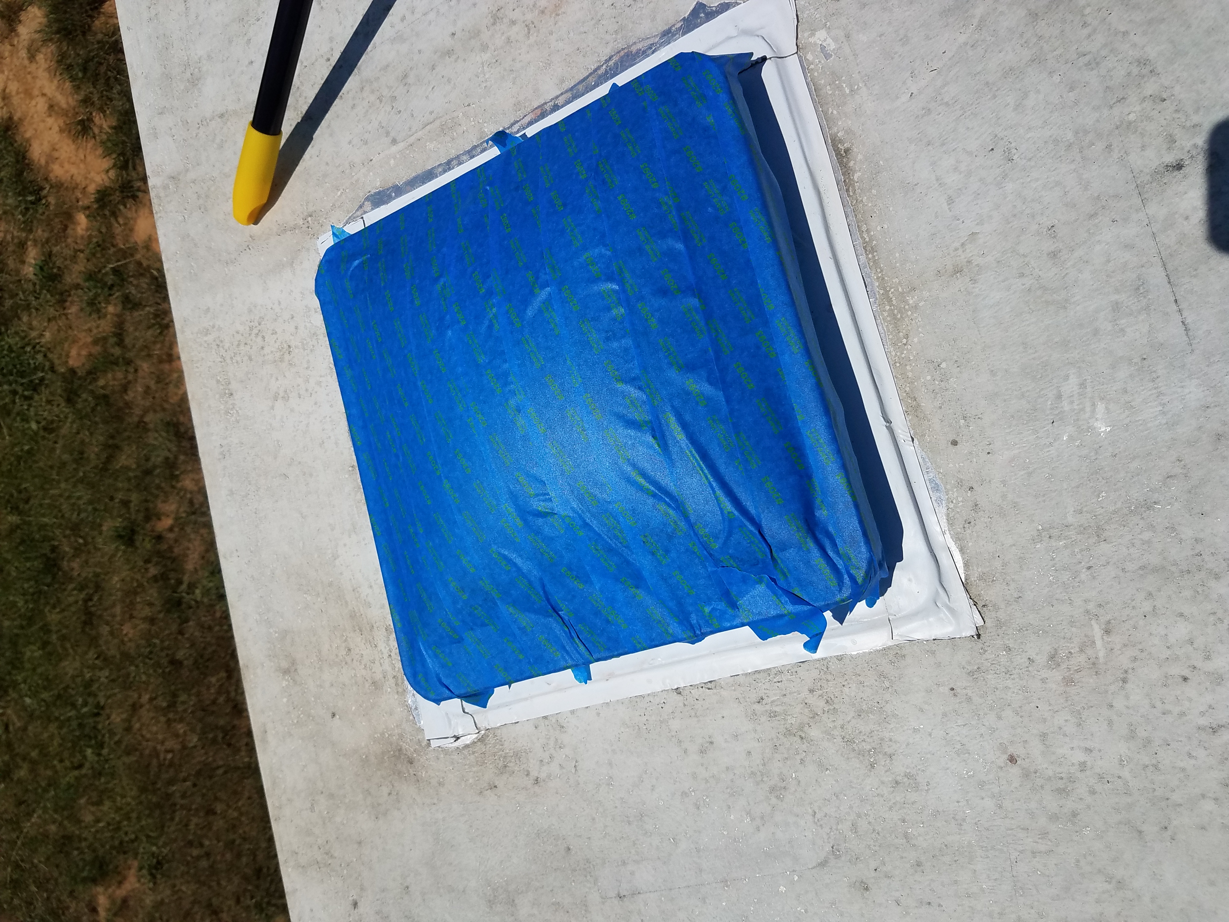 The travel trailer roof vent covered with tape before painting