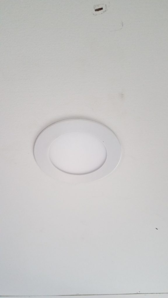 A recessed puck light installed in the ceiling