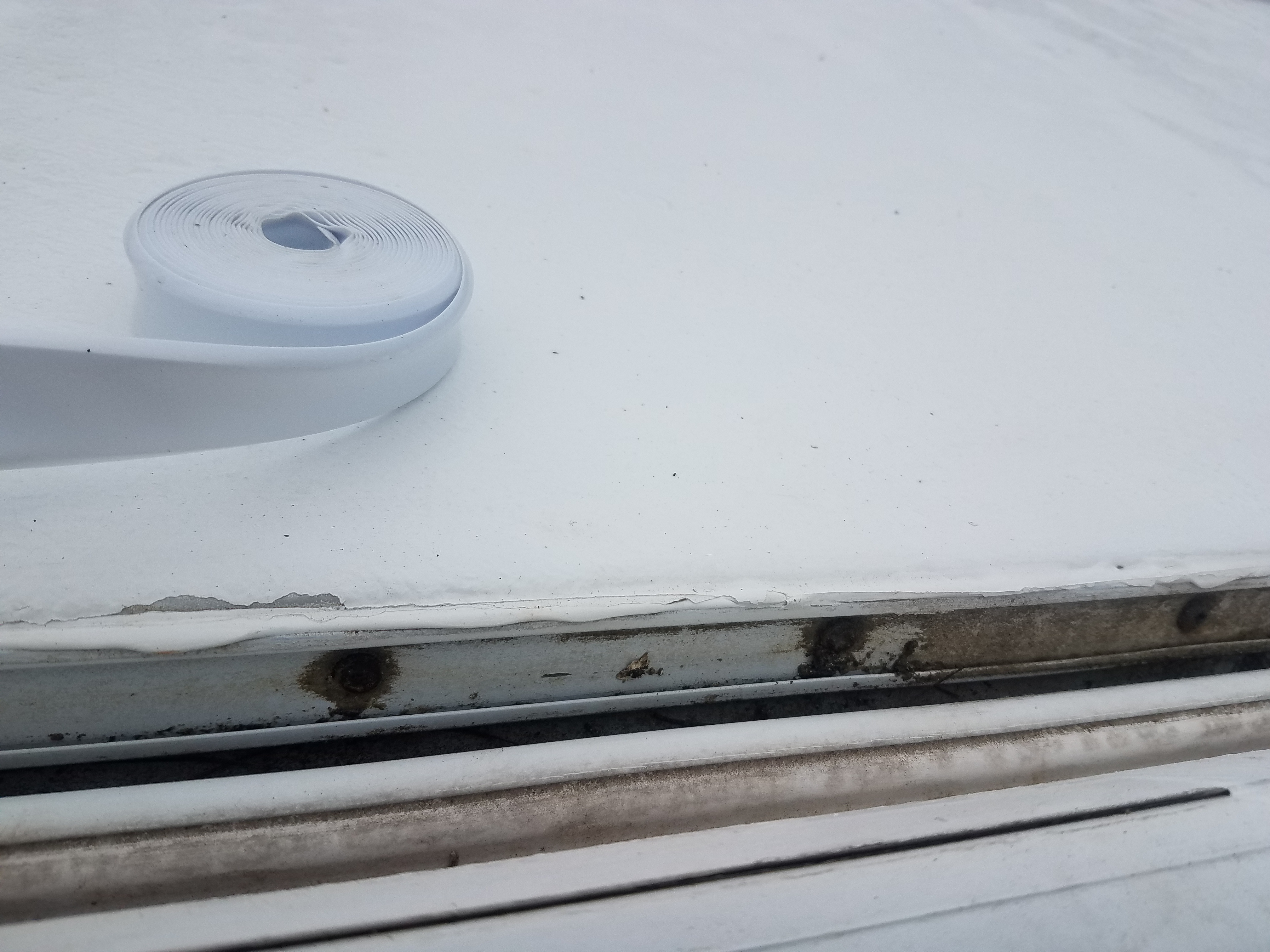 Replacing the vinyl insert molding on the roof trim at the sides of the travel trailer