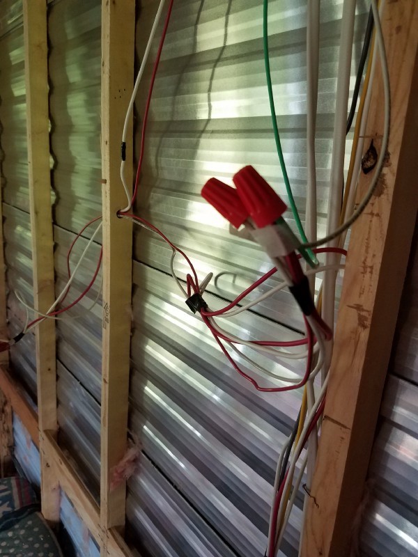 DC wiring in the travel trailer shown in front of the exposed walls and framing.