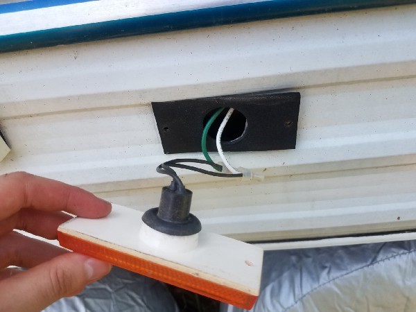 Removing the exterior running lights from the travel trailer to replace with LED