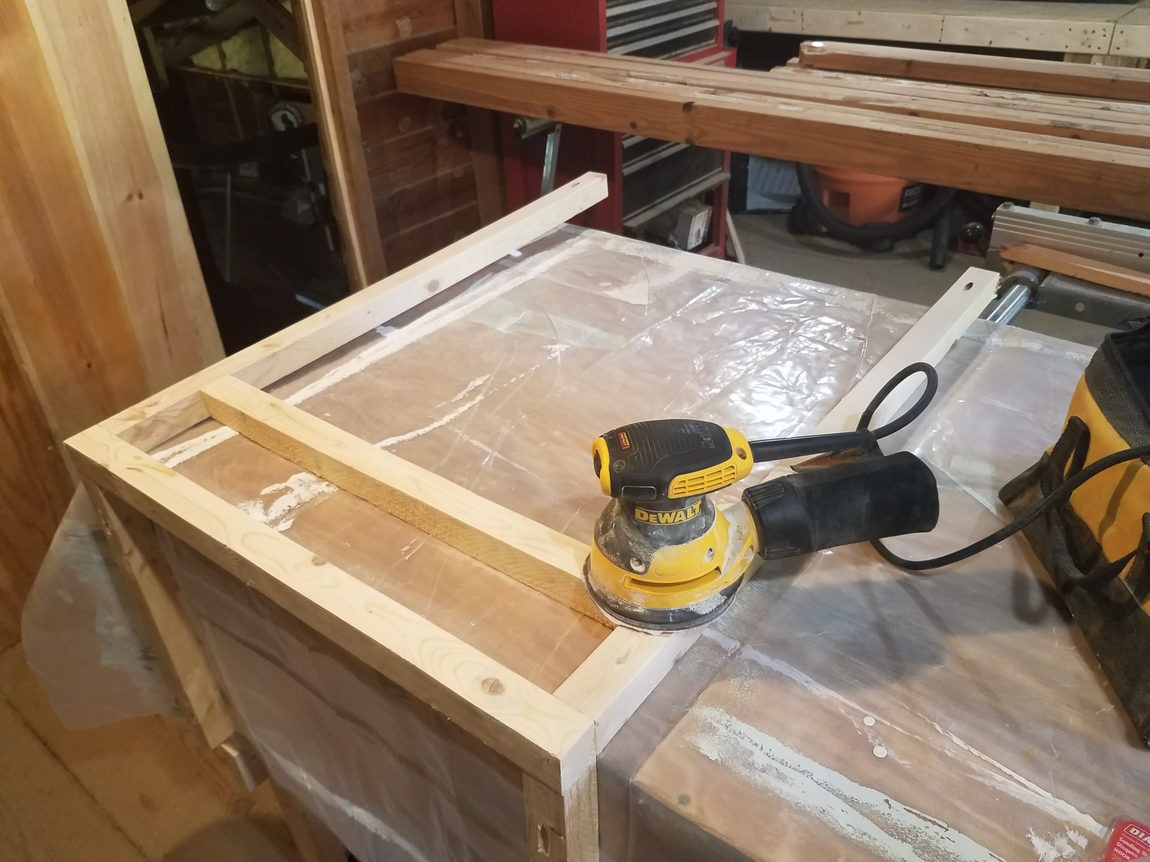 Sanding the frame of the kitchen cabinets for the travel trailer