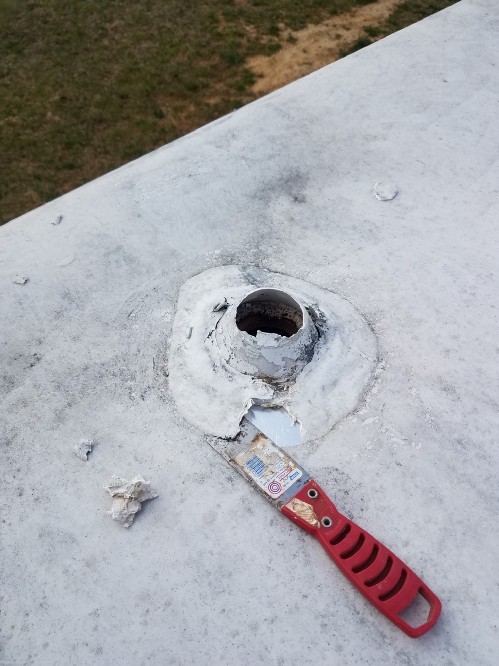 On the travel trailer roof, an old sewer vent is broken and needs to be repaired.