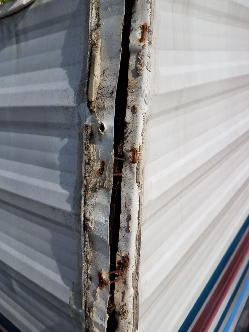 The front edge of the travel trailer with the aluminum corner molding removed.