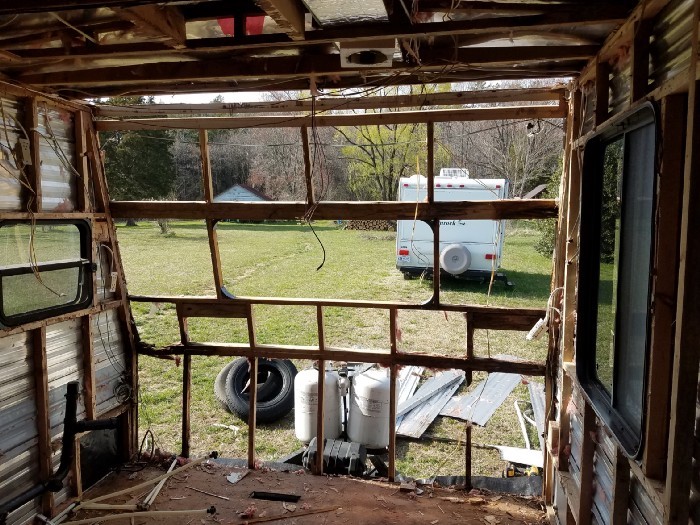 A travel trailer with the siding on the front removed, as seen from inside the trailer looking out.