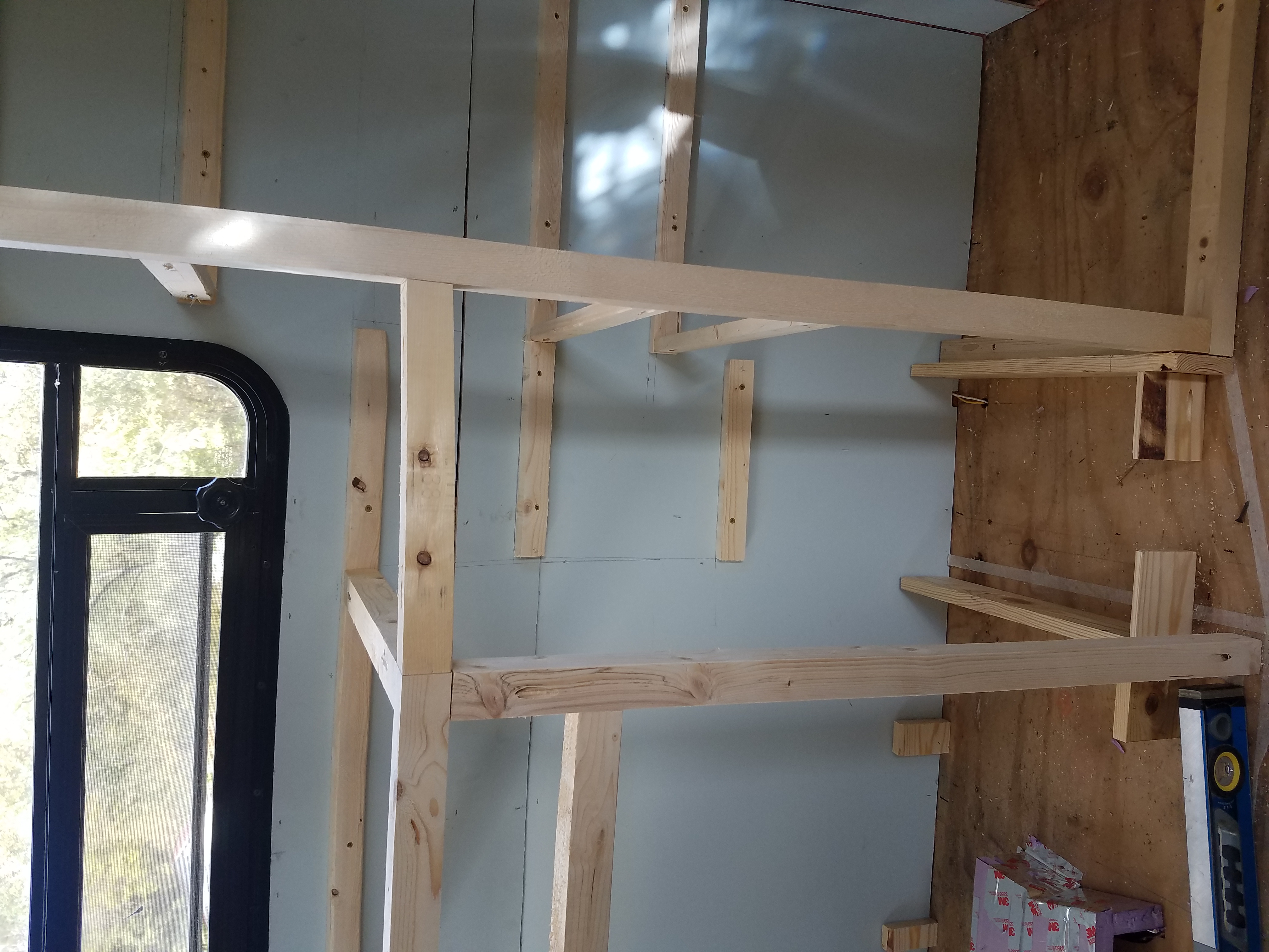 Front view of the angled shelving between the sink and pantry inside of the travel trailer kitchen
